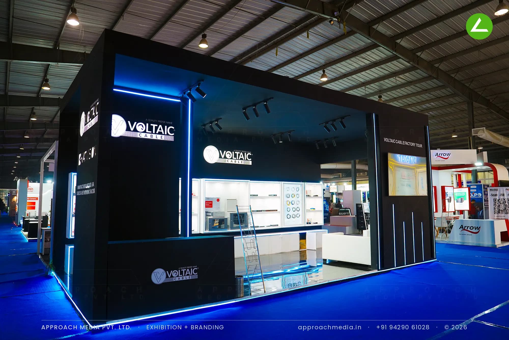 Voltaic Cable exhibition stall design at FITAG Tech Expo Gandhinagar, matte black bay with blue LED lines and lit vitrines